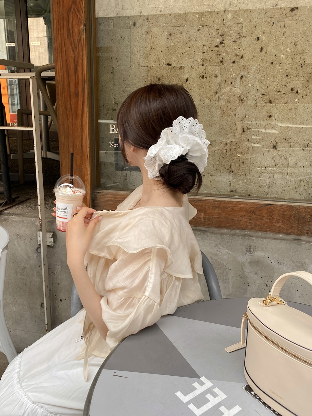 ピンク系のタンクトップ、ベージュ系のショルダーバッグ、ホワイト系のブルゾンを着用したレディースの夏コーディネートの4枚目の写真