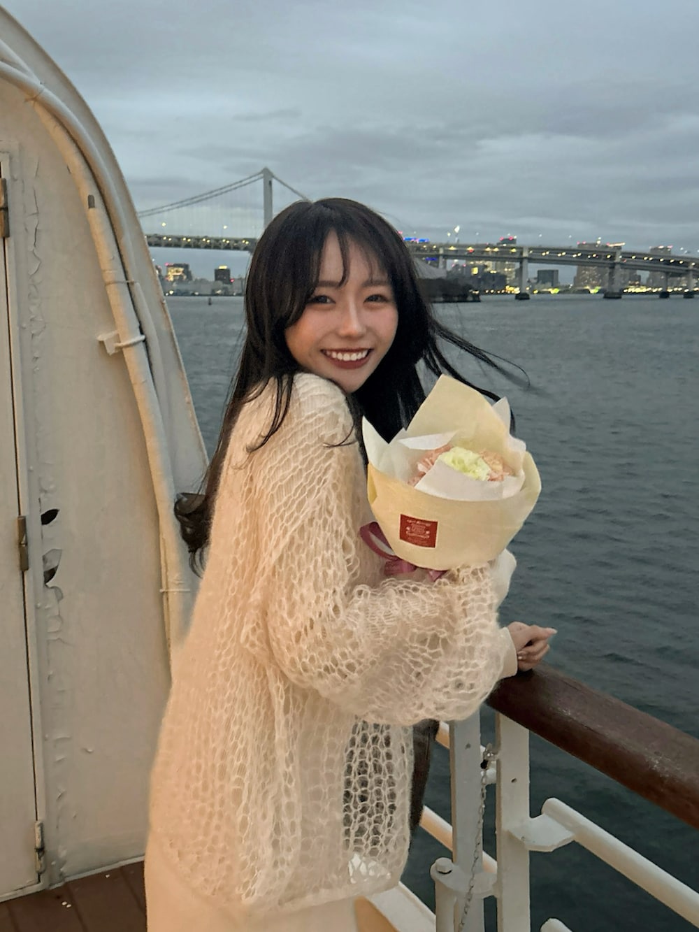 ホワイト系のワンピース、ホワイト系のニット/セーター、ホワイト系のブーツを着用したレディースの春コーディネートの2枚目の写真