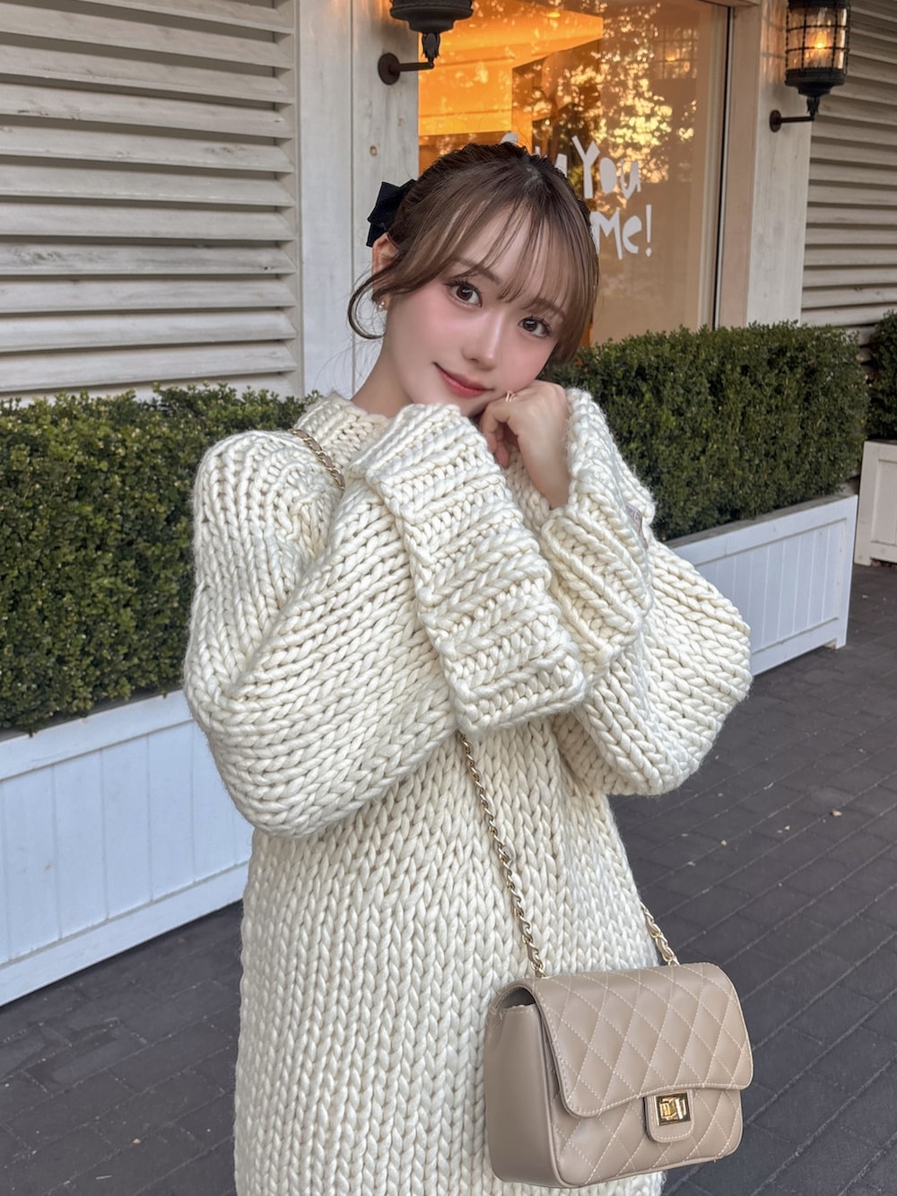 ホワイト系のトップス、ベージュ系のショルダーバッグ、ホワイト系のスカートを着用したレディースの冬コーディネートの4枚目の写真