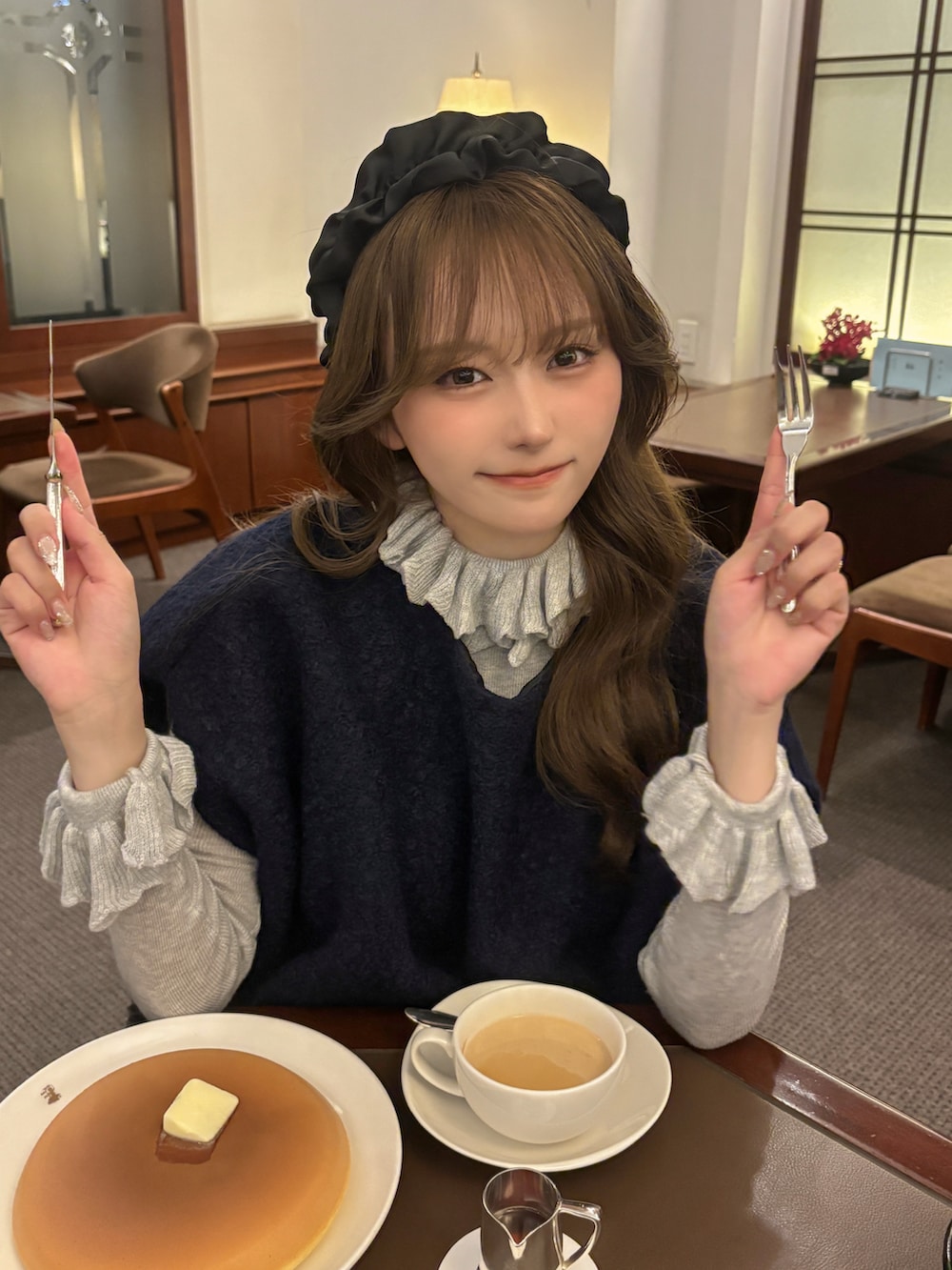 ブラック系のパンプス、ブルー系のトップス、ブラック系のスカートを着用したレディースの秋コーディネートの3枚目の写真