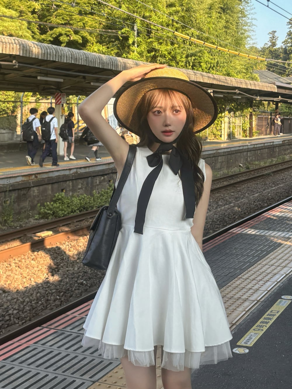 ブラック系のサンダル、ホワイト系のワンピース/ドレス、ブラック系のバッグを着用したレディースの夏コーディネートの4枚目の写真