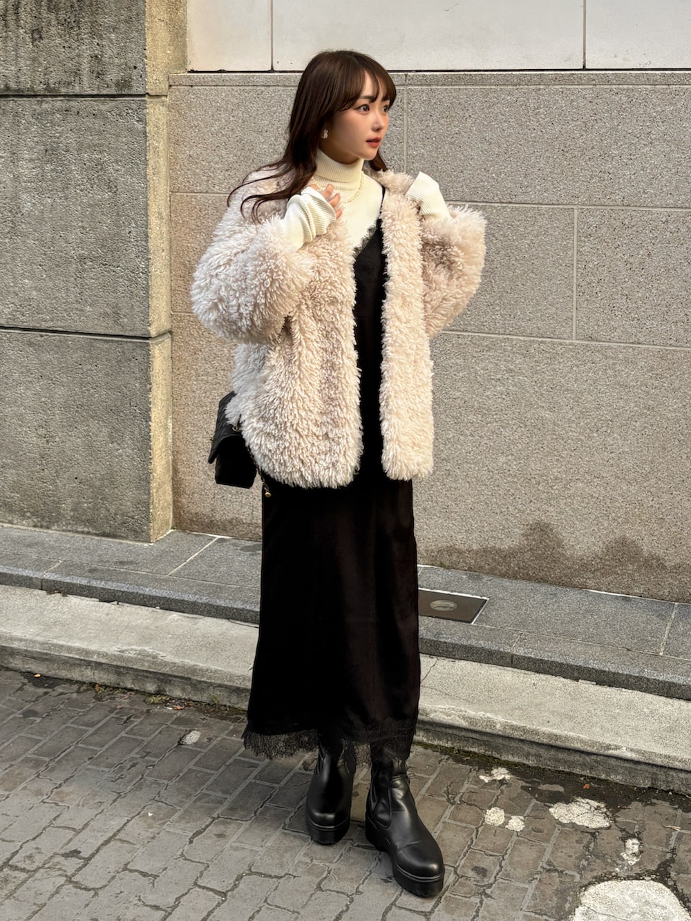 ホワイト系のその他アウター、ホワイト系のニット/セーター、ブラック系のワンピースを着用したレディースの冬コーディネートの3枚目の写真