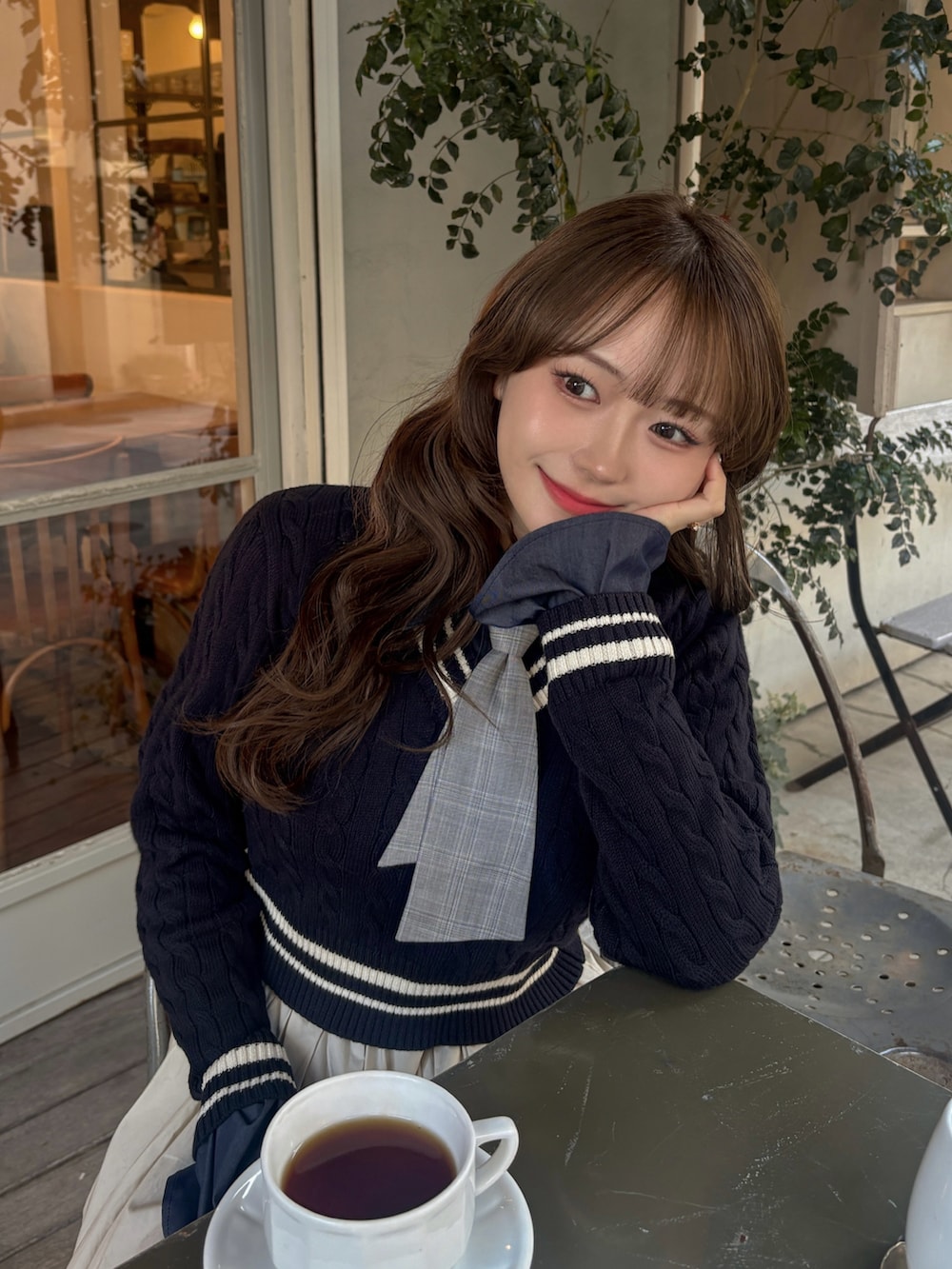 ブルー系のニット/セーター、ベージュ系のショルダーバッグ、ホワイト系のワンピースを着用したレディースの冬コーディネートの4枚目の写真