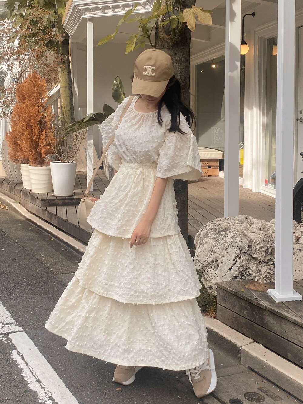 ホワイト系のワンピース、ホワイト系のバッグ、ブラウン系のスニーカーを着用したレディースの秋コーディネートの3枚目の写真