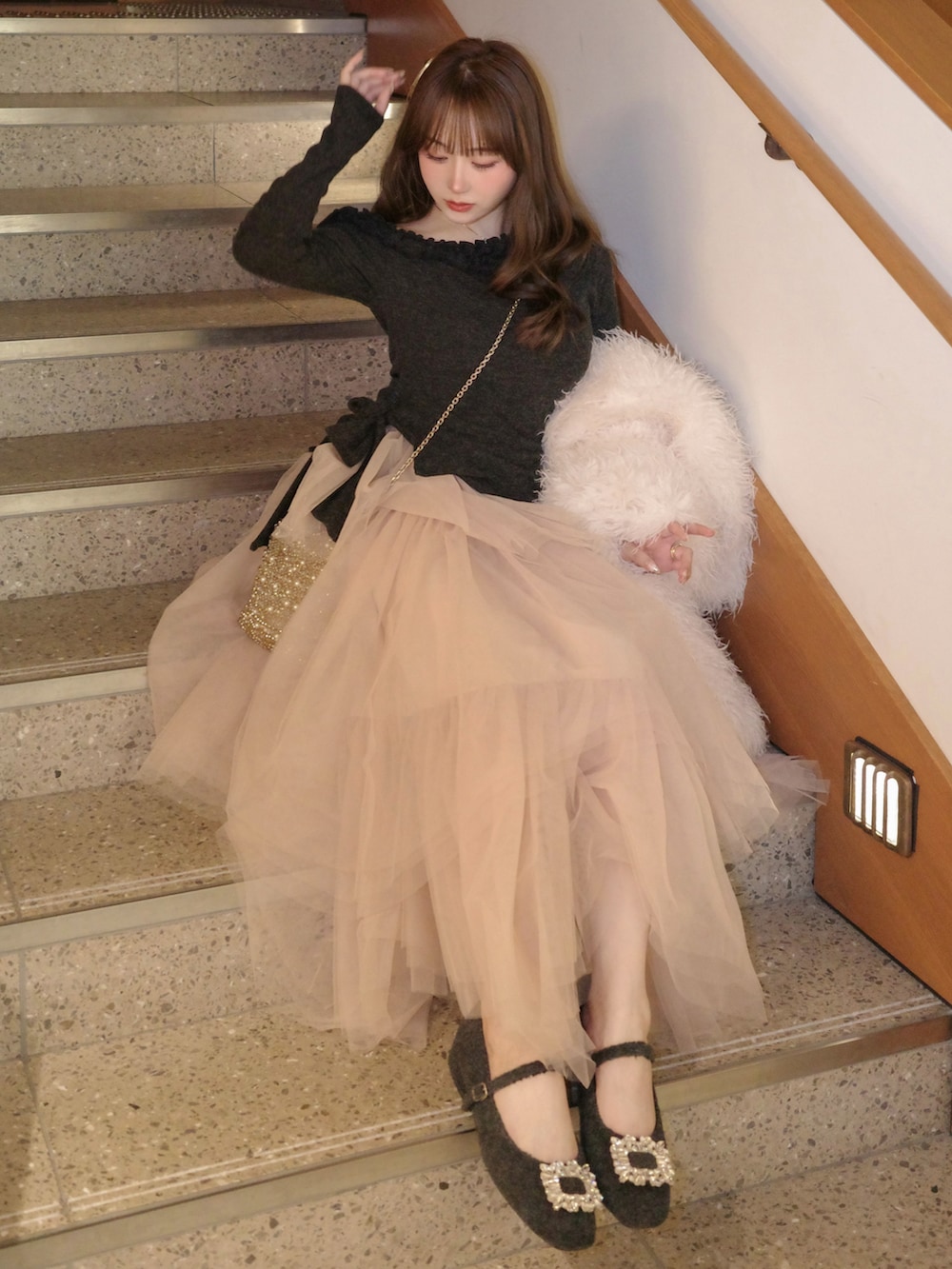 グレー系のシューズ、ピンク系のスカート、グレー系のセットアップを着用したレディースの冬コーディネートの2枚目の写真