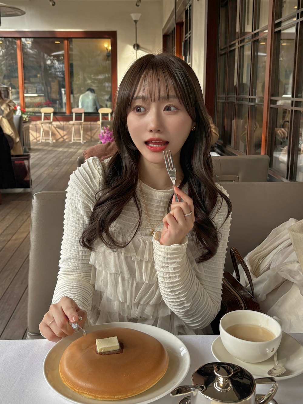 ホワイト系のTシャツ/カットソー、ホワイト系のトップス、ブラウン系のスカートを着用したレディースの冬コーディネートの2枚目の写真