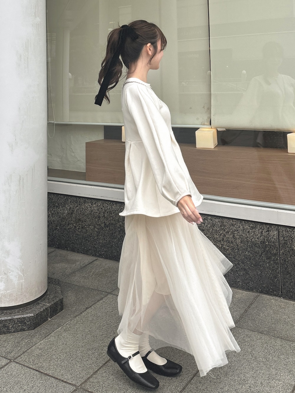 ブラック系のパンプス、ホワイト系のスカート、ホワイト系のスウェットを着用したレディースの春コーディネートの2枚目の写真