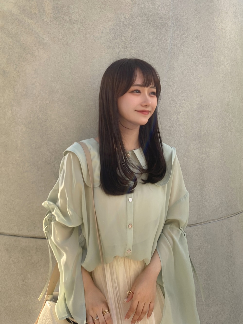 ベージュ系のスカート、ホワイト系のショルダーバッグ、ホワイト系のサンダルを着用したレディースの夏コーディネートの3枚目の写真