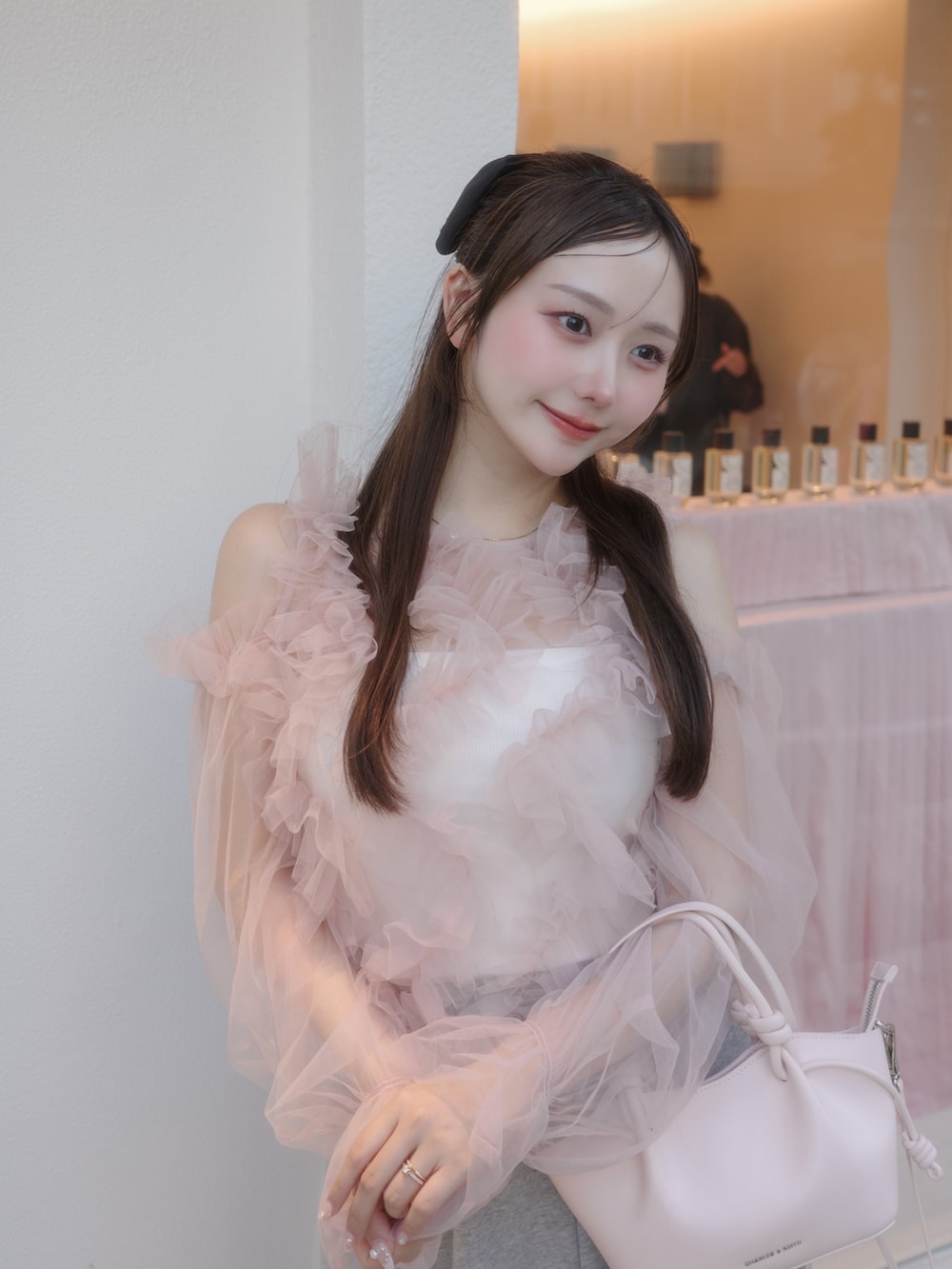 ブラック系のシューズ、グレー系のパンツ、ピンク系のトップスを着用したレディースの春コーディネートの5枚目の写真