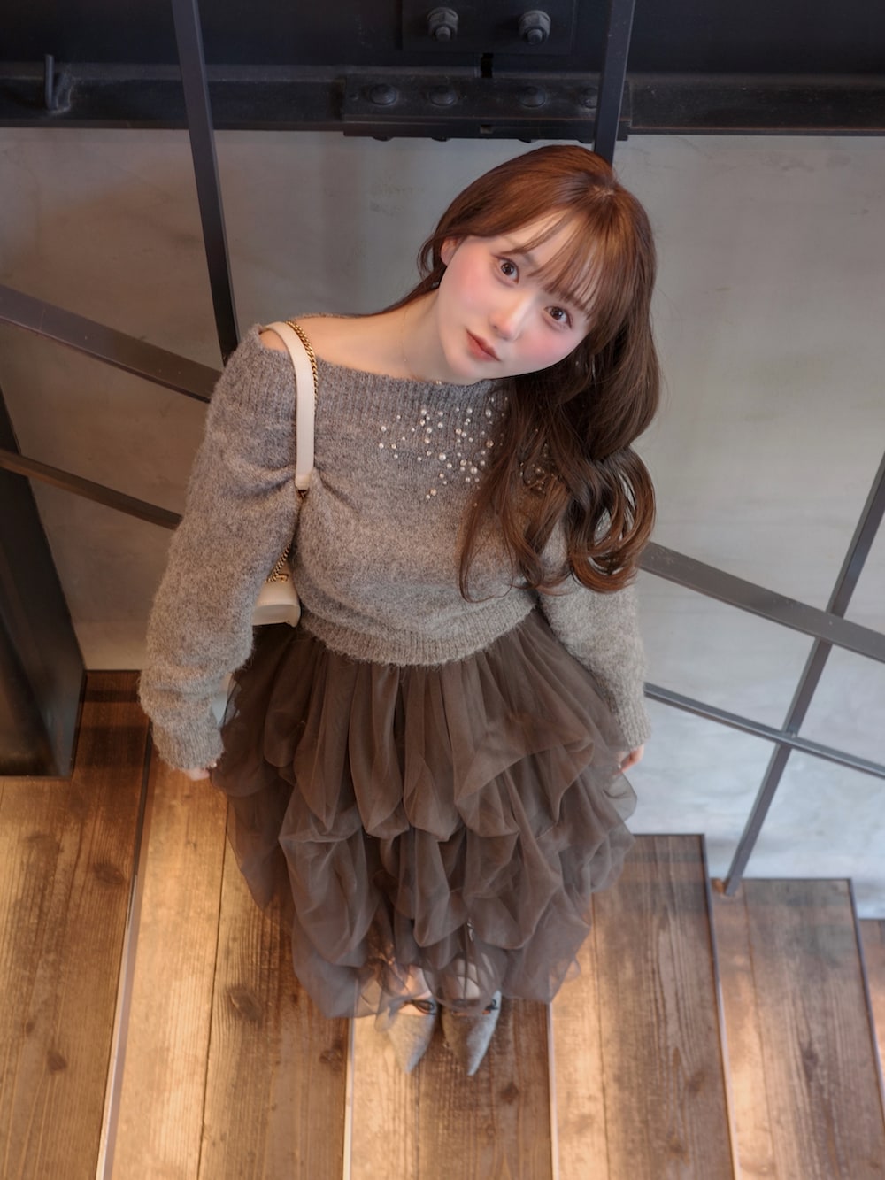 グレー系のパンプス、グレー系のニット/セーター、グレー系のスカートを着用したレディースの春コーディネートの3枚目の写真