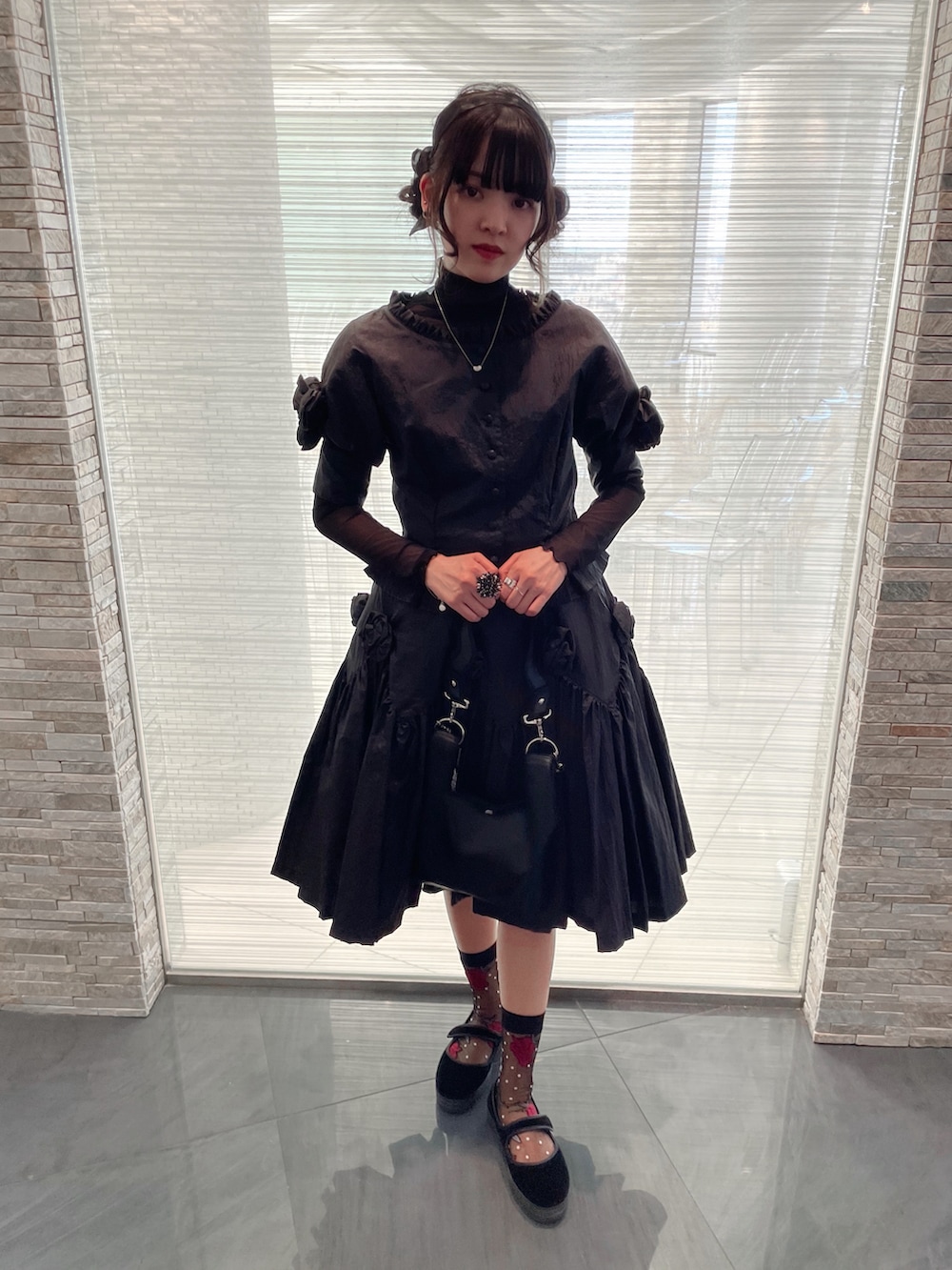 ブラック系のバッグ、ブラック系のその他シューズ、シルバー系のネックレスを着用したレディースの春コーディネートの2枚目の写真