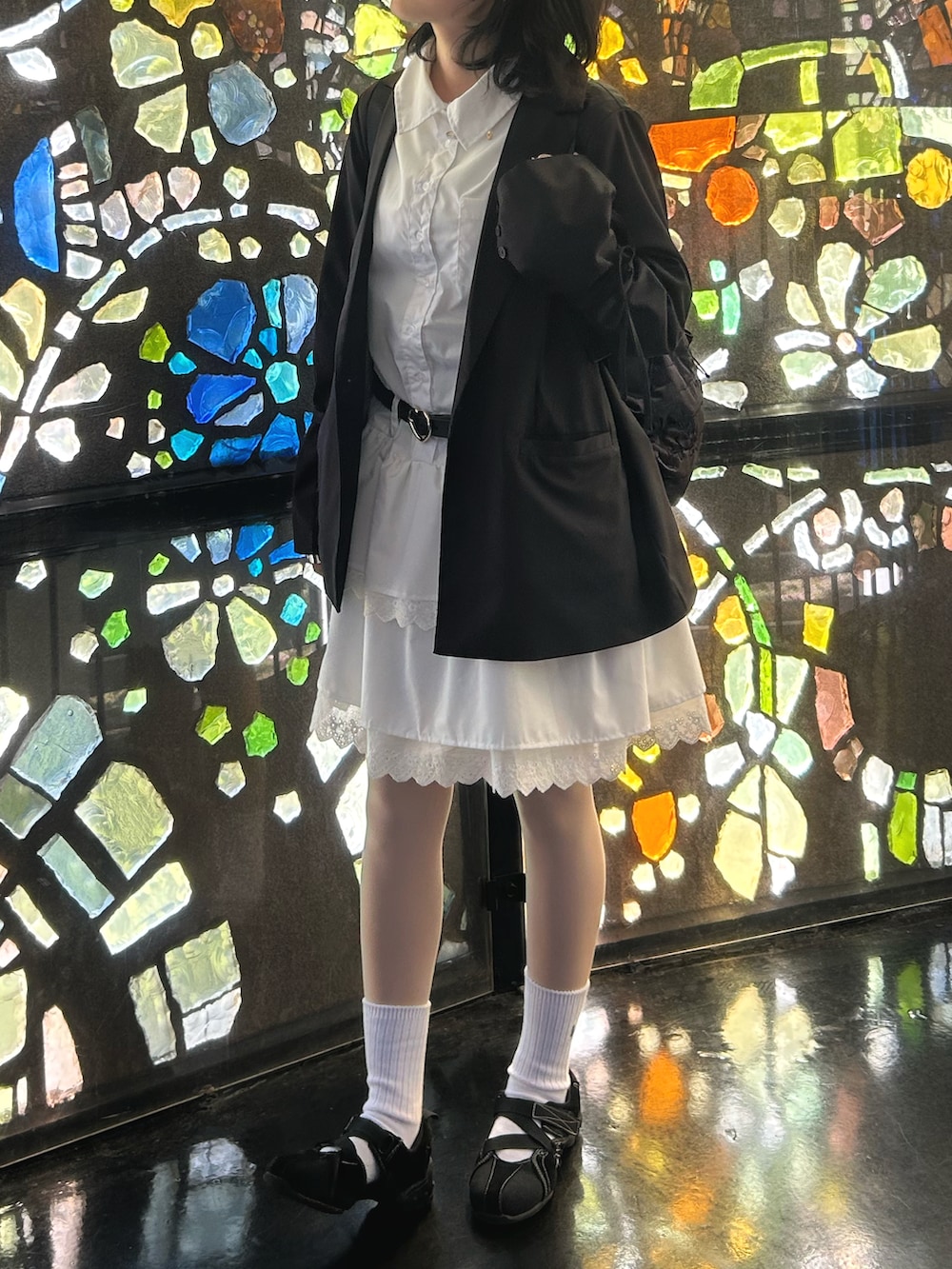 ホワイト系のワンピース、ブラック系のテーラードジャケット、ブラック系のベルトを着用したレディースの秋コーディネートの2枚目の写真