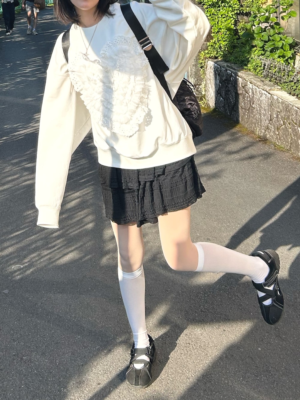 ホワイト系のスウェット、ブラック系のスカートを着用したレディースの秋コーディネートの2枚目の写真