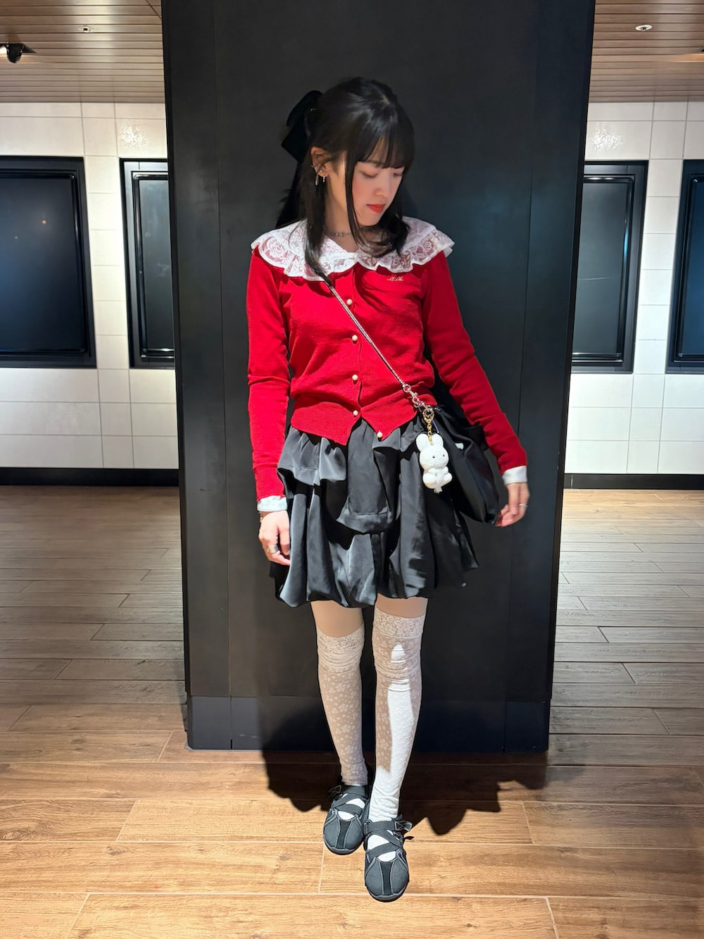 ブラック系のスカート、レッド系のトップス、ホワイト系のシャツ/ブラウスを着用したレディースの春コーディネートの2枚目の写真