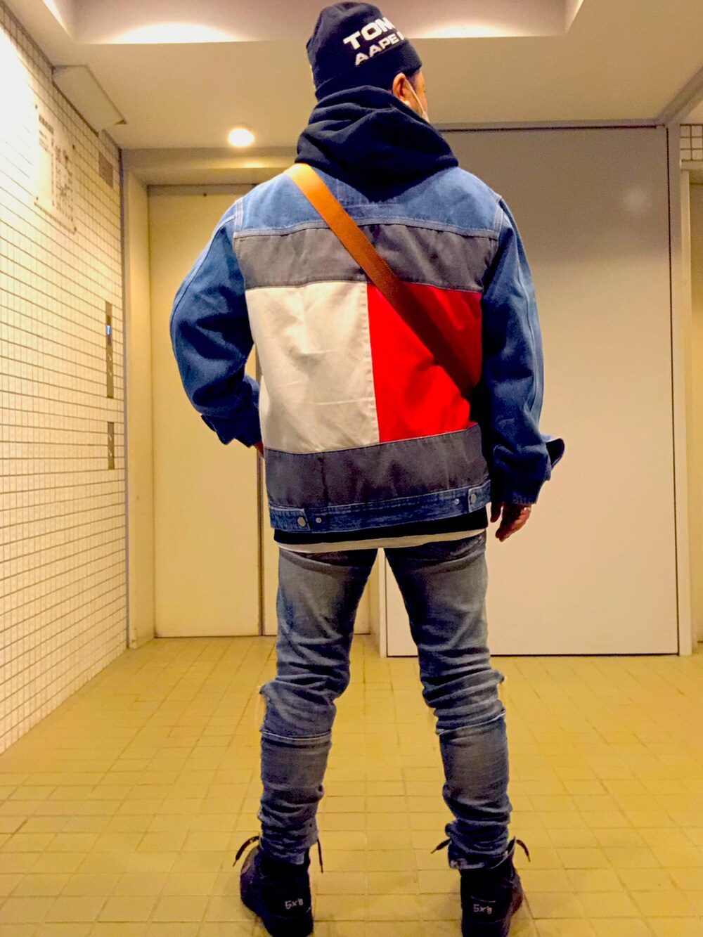 ブルー系のデニムジャケット、ブラウン系のショルダーバッグ、ブルー系のデニムパンツを着用したメンズの冬コーディネートの4枚目の写真