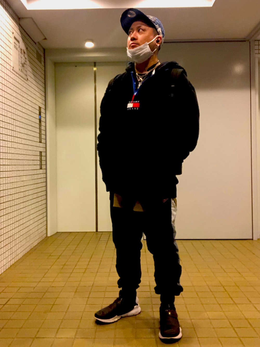 ブラック系のパーカー、ブラック系のスウェットパンツ、ブラック系のスリッポンを着用したメンズの冬コーディネートの3枚目の写真