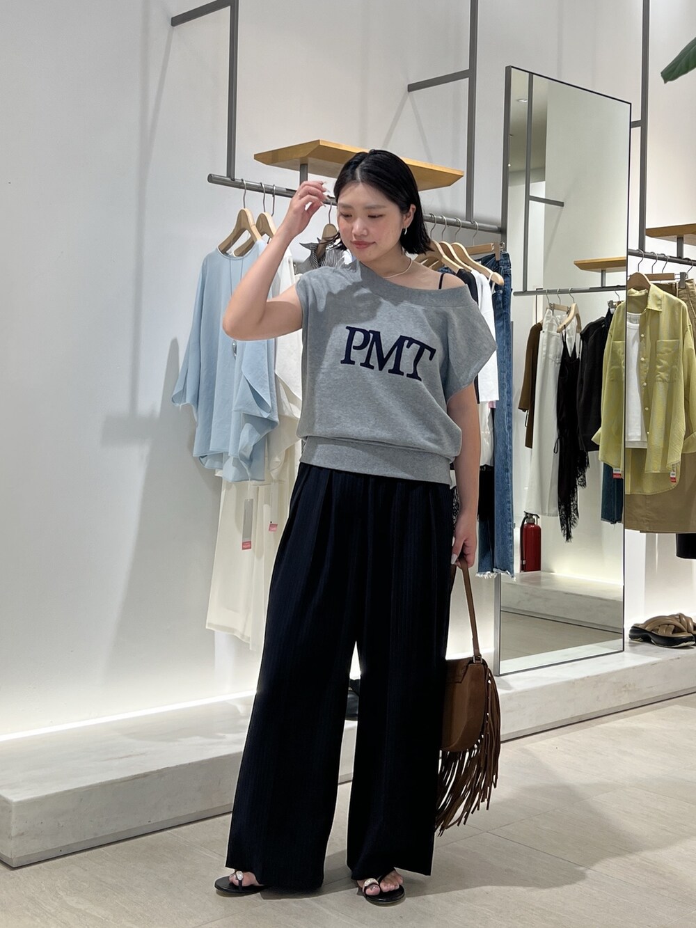 グレー系のTシャツ/カットソー、ブラック系のその他パンツ、イエロー系のショルダーバッグを着用したレディースの夏コーディネートの2枚目の写真