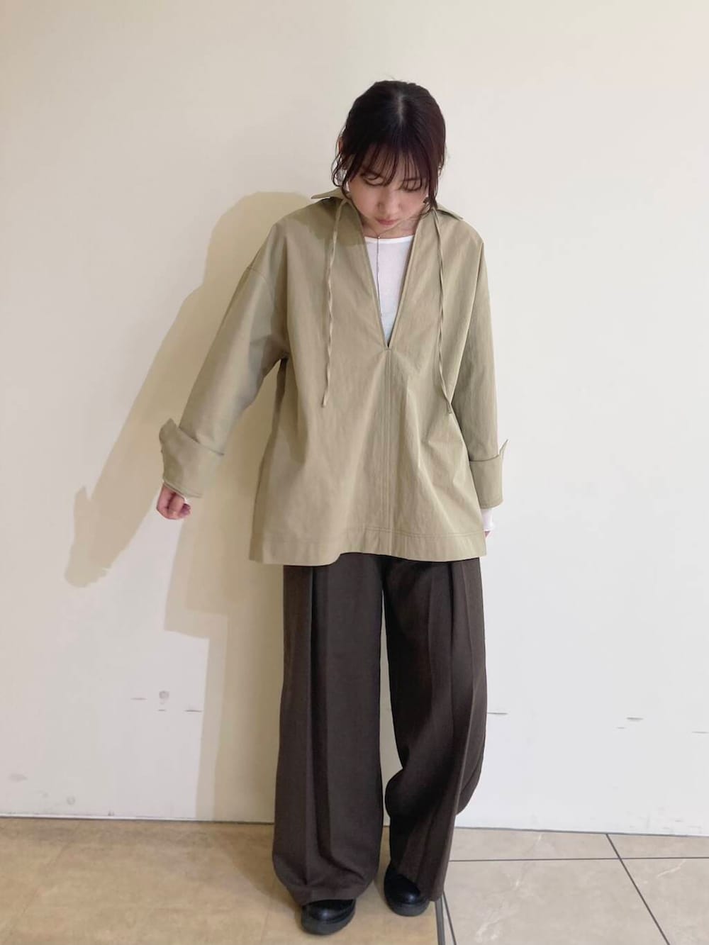 ホワイト系のTシャツ/カットソー、ブラウン系のその他パンツ、ベージュ系のシャツ/ブラウスを着用したレディースの冬コーディネートの3枚目の写真