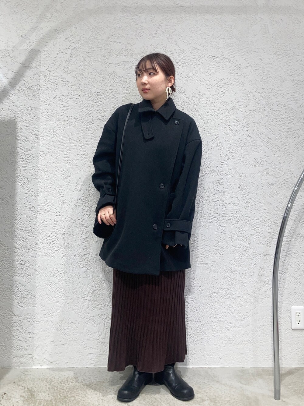 レッド系のワンピース、ブラウン系のニット/セーター、ブラック系のショルダーバッグを着用したレディースの秋コーディネートの3枚目の写真