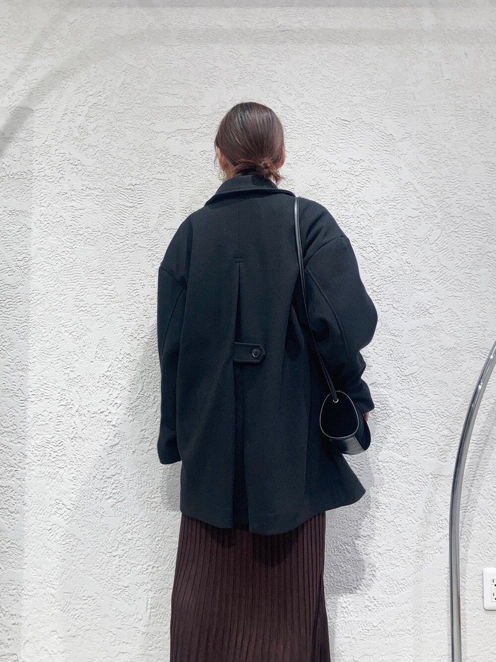 レッド系のワンピース、ブラウン系のニット/セーター、ブラック系のショルダーバッグを着用したレディースの秋コーディネートの4枚目の写真