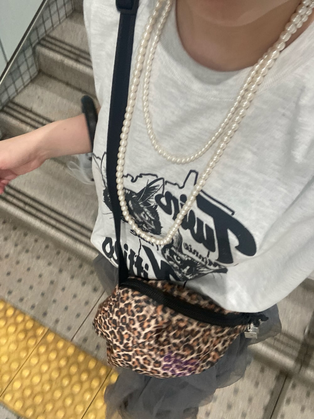 グレー系のスカート、シルバー系のネックレスを着用したレディースの夏コーディネートの2枚目の写真