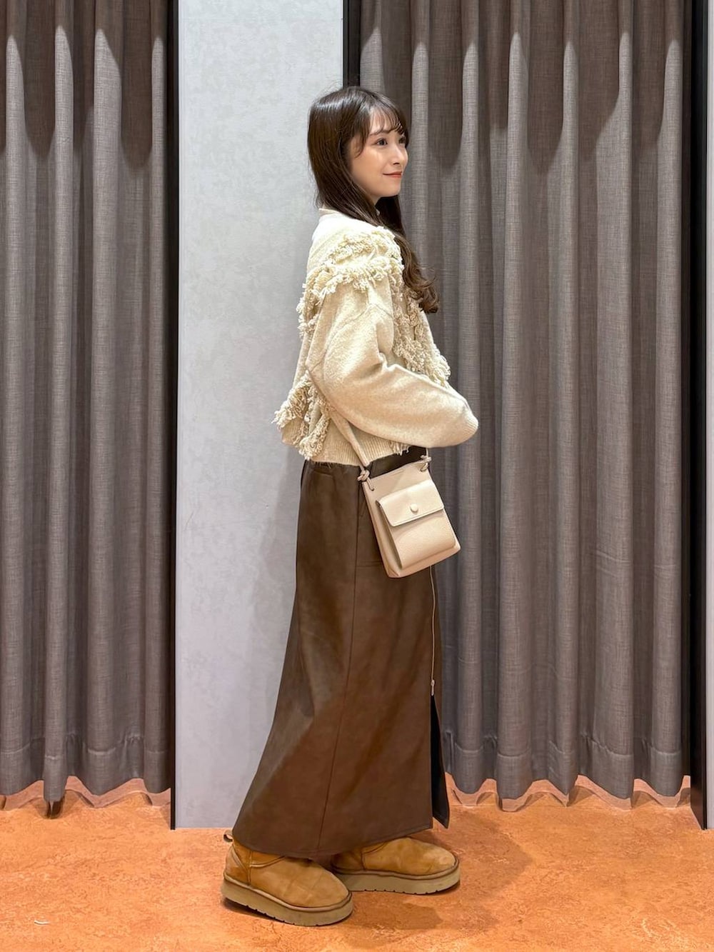 ホワイト系のニット/セーター、ホワイト系のその他アウター、ブラウン系のスカートを着用したレディースの冬コーディネートの5枚目の写真