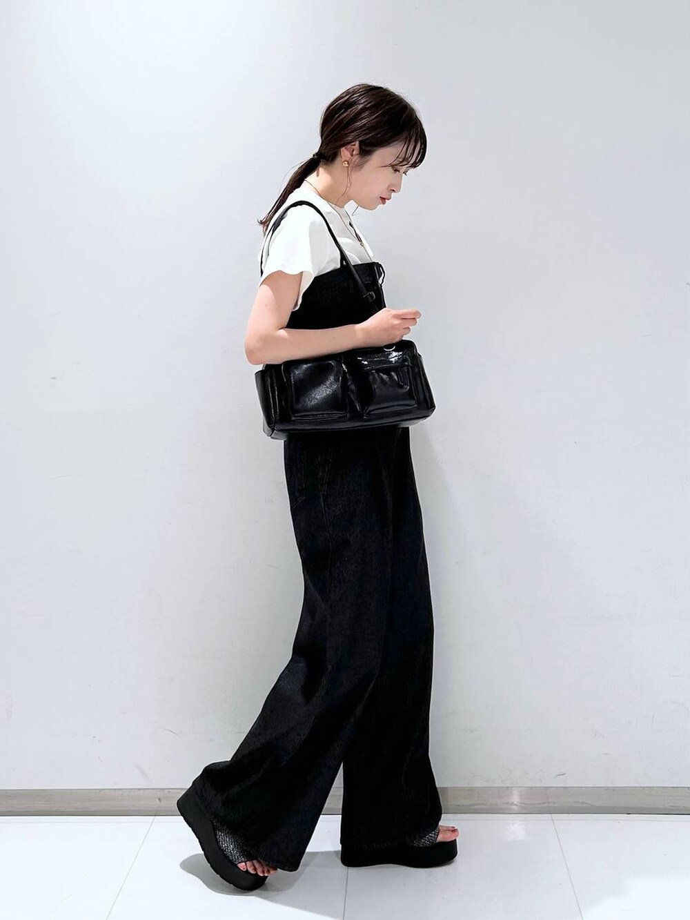 ブラック系のサンダル、ホワイト系のTシャツ/カットソー、ブラック系のボストンバッグを着用したレディースの夏コーディネートの4枚目の写真