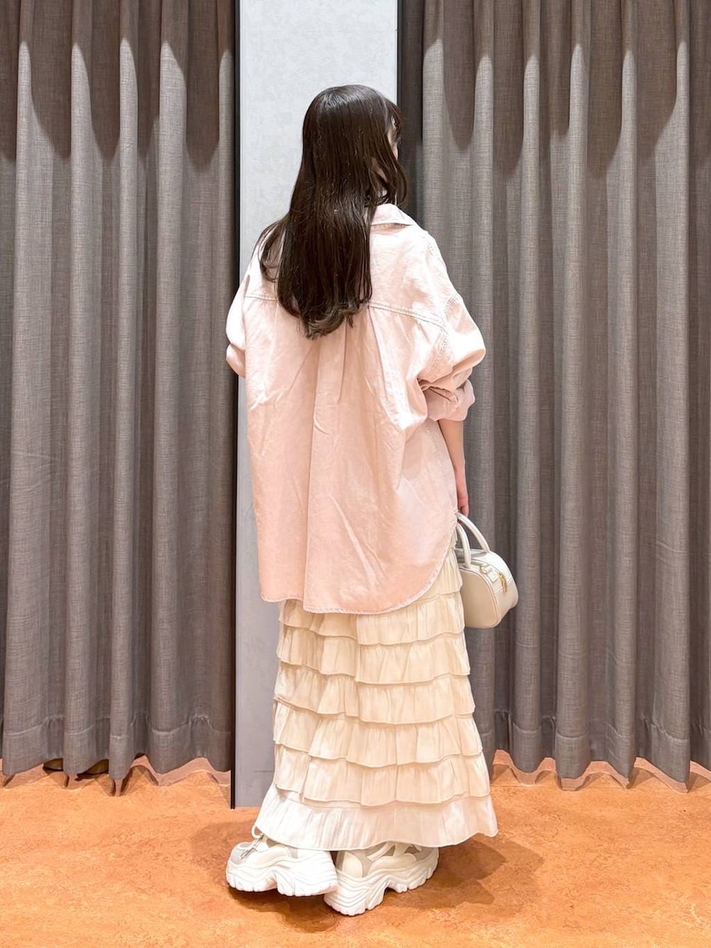 ホワイト系のスカート、ホワイト系のボストンバッグ、ピンク系のシャツ/ブラウスを着用したレディースの冬コーディネートの5枚目の写真