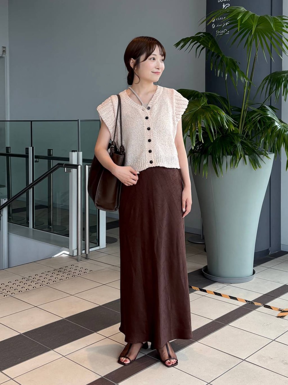 ブラウン系のスカート、ブラウン系のトートバッグ、ブラウン系のサンダルを着用したレディースの夏コーディネートの3枚目の写真