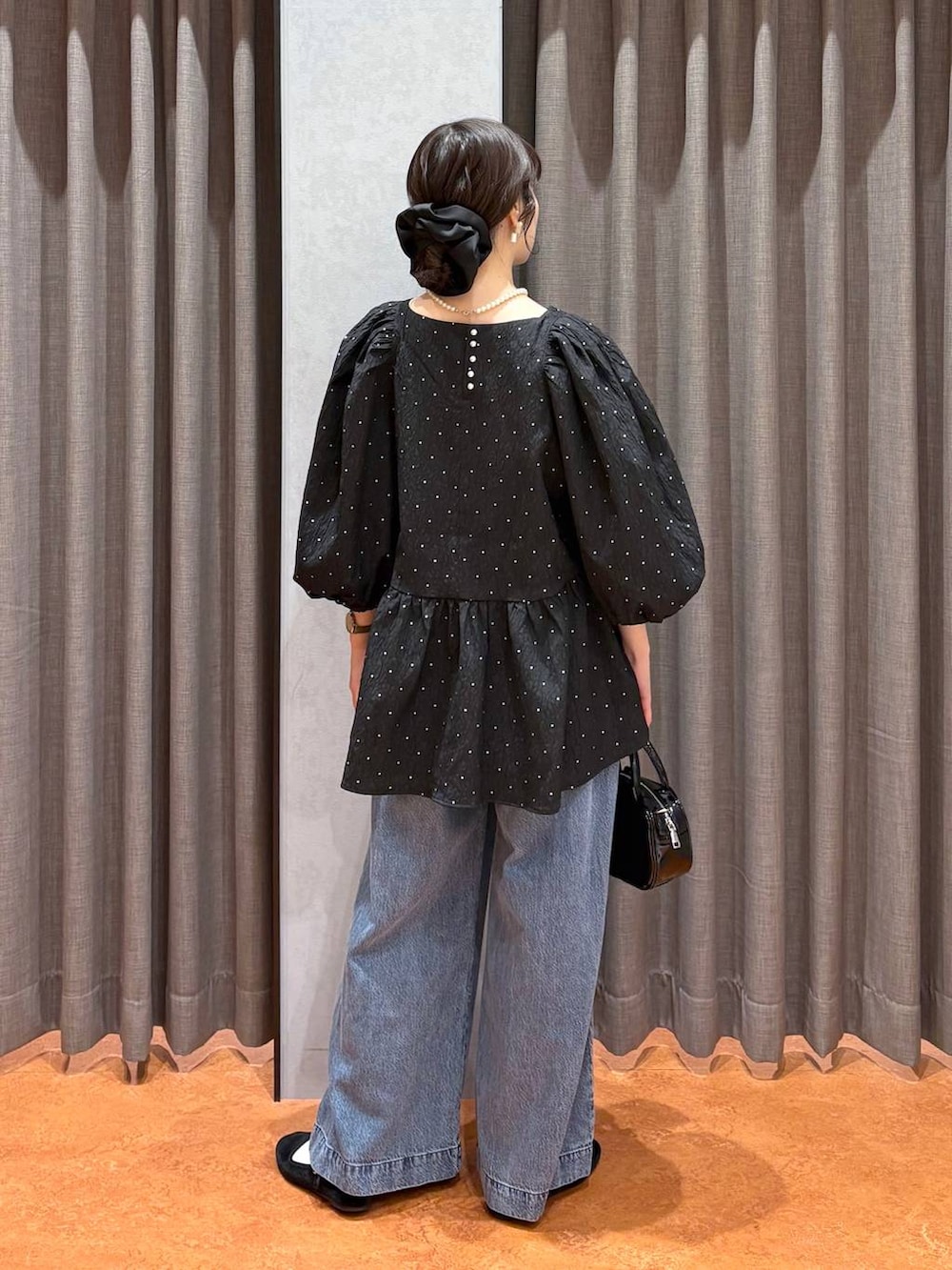 ブラック系のボストンバッグ、ブラック系のシャツ/ブラウス、ブルー系のデニムパンツを着用したレディースの冬コーディネートの5枚目の写真