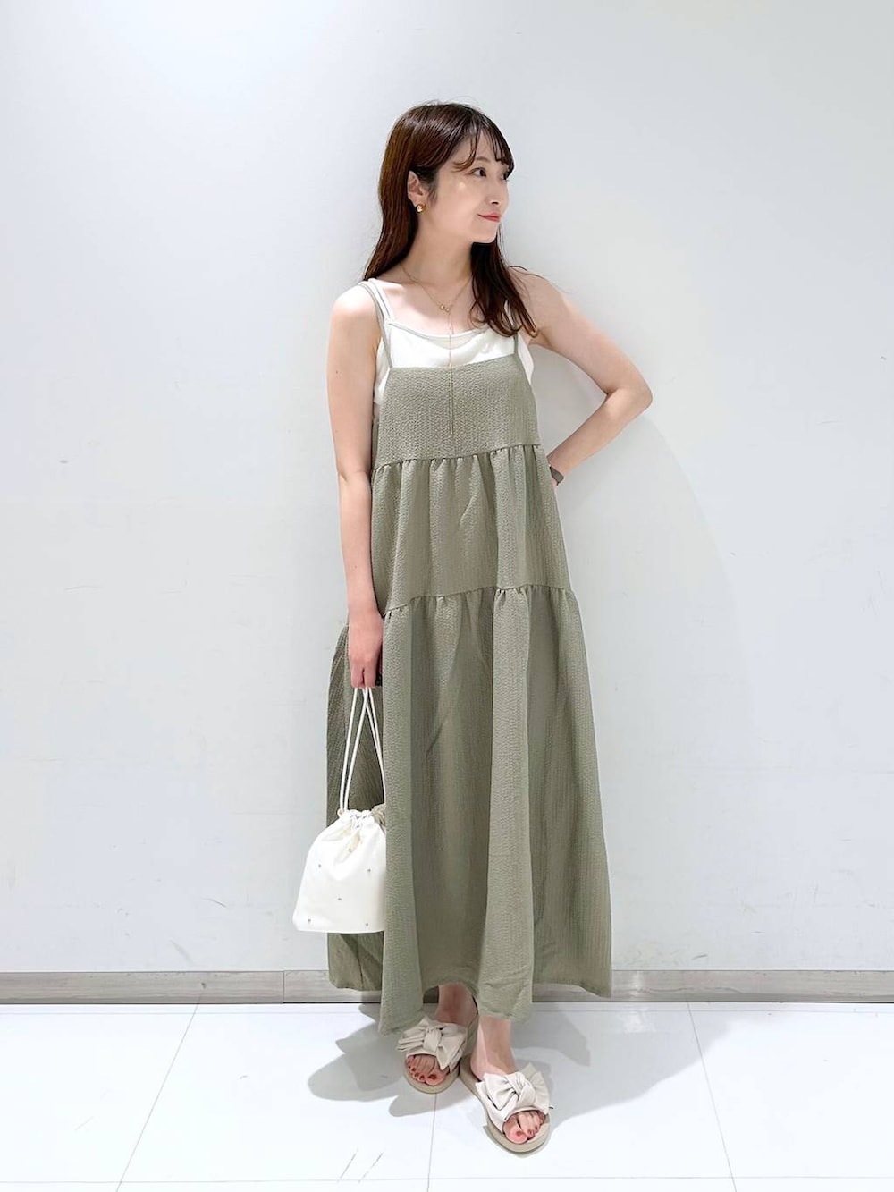 ホワイト系のTシャツ/カットソー、グリーン系のワンピース、ホワイト系のショルダーバッグを着用したレディースの夏コーディネートの2枚目の写真
