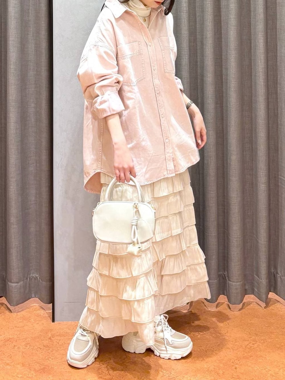 ホワイト系のスカート、ホワイト系のボストンバッグ、ピンク系のシャツ/ブラウスを着用したレディースの冬コーディネートの3枚目の写真