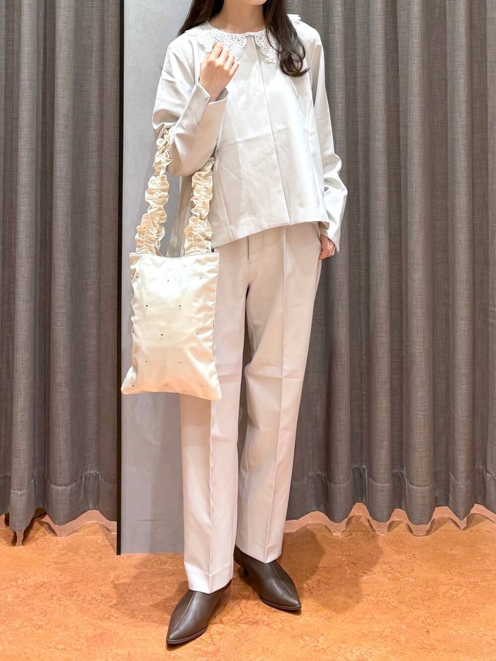 ブラウン系のブーツ、ホワイト系のテーラードジャケット、ホワイト系のその他パンツを着用したレディースの冬コーディネートの2枚目の写真