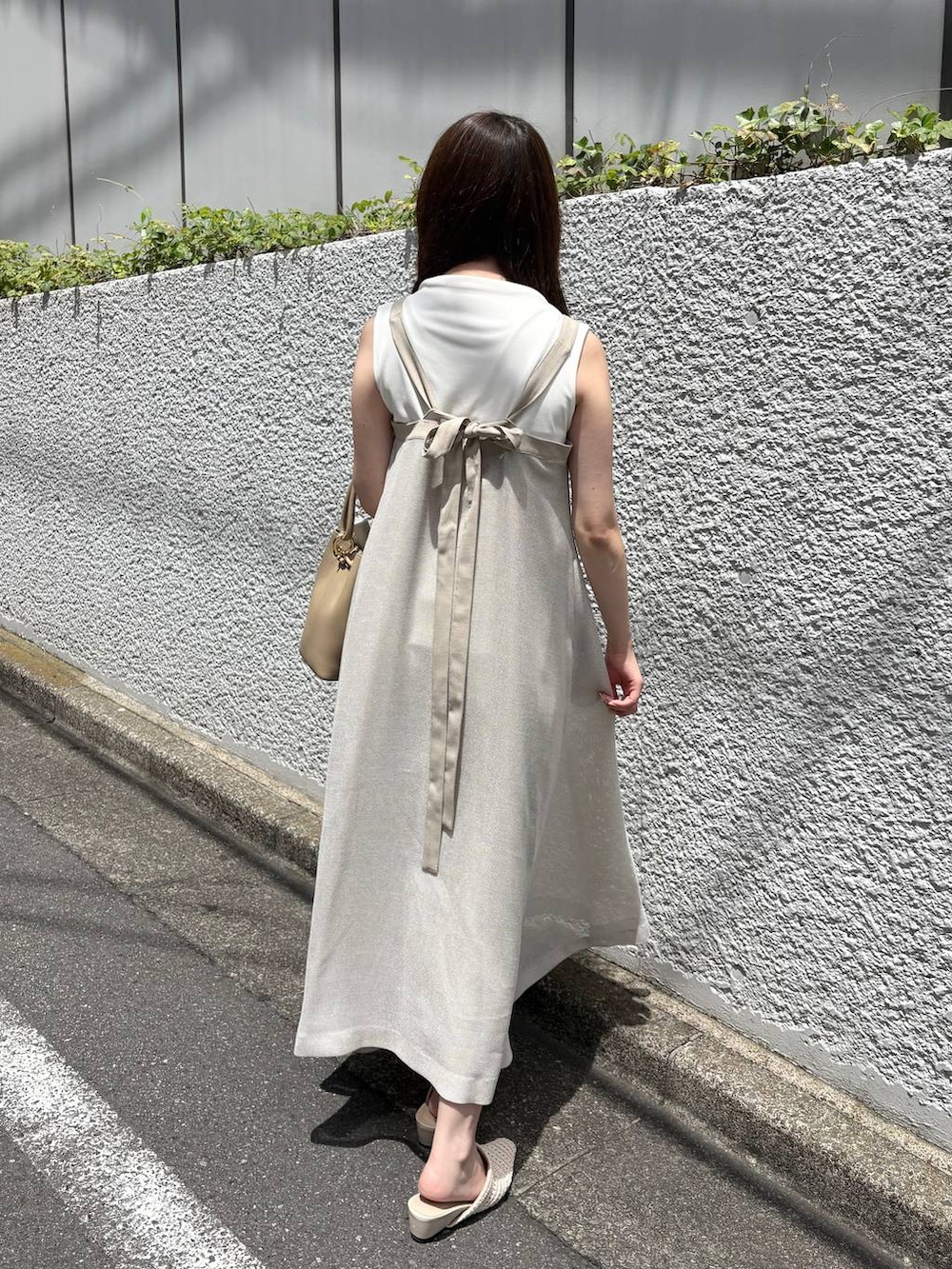 ベージュ系のワンピース、ホワイト系のTシャツ/カットソーを着用したレディースの夏コーディネートの5枚目の写真