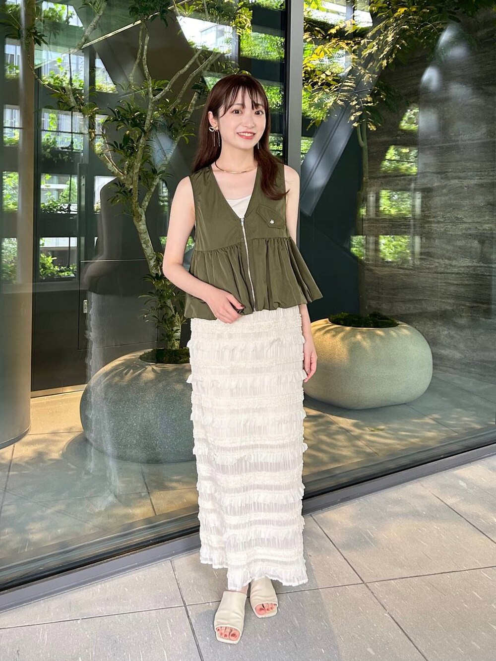 ホワイト系のTシャツ/カットソー、ホワイト系のサンダル、ホワイト系のスカートを着用したレディースの夏コーディネートの2枚目の写真