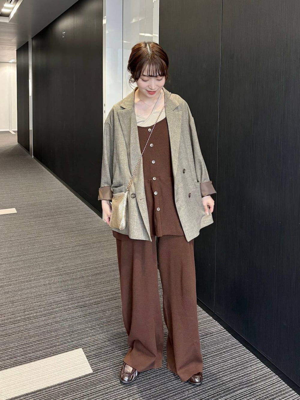 ゴールド系のショルダーバッグ、ブラウン系のテーラードジャケット、ブラウン系のつなぎ/オールインワンを着用したレディースの春コーディネートの2枚目の写真