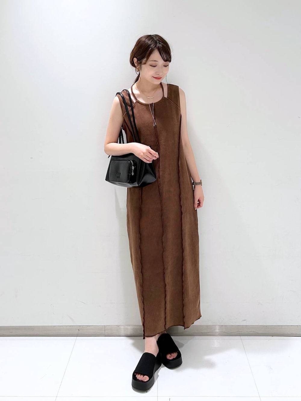 ブラック系のサンダル、ブラウン系のワンピース、ブラック系のショルダーバッグを着用したレディースの夏コーディネートの2枚目の写真