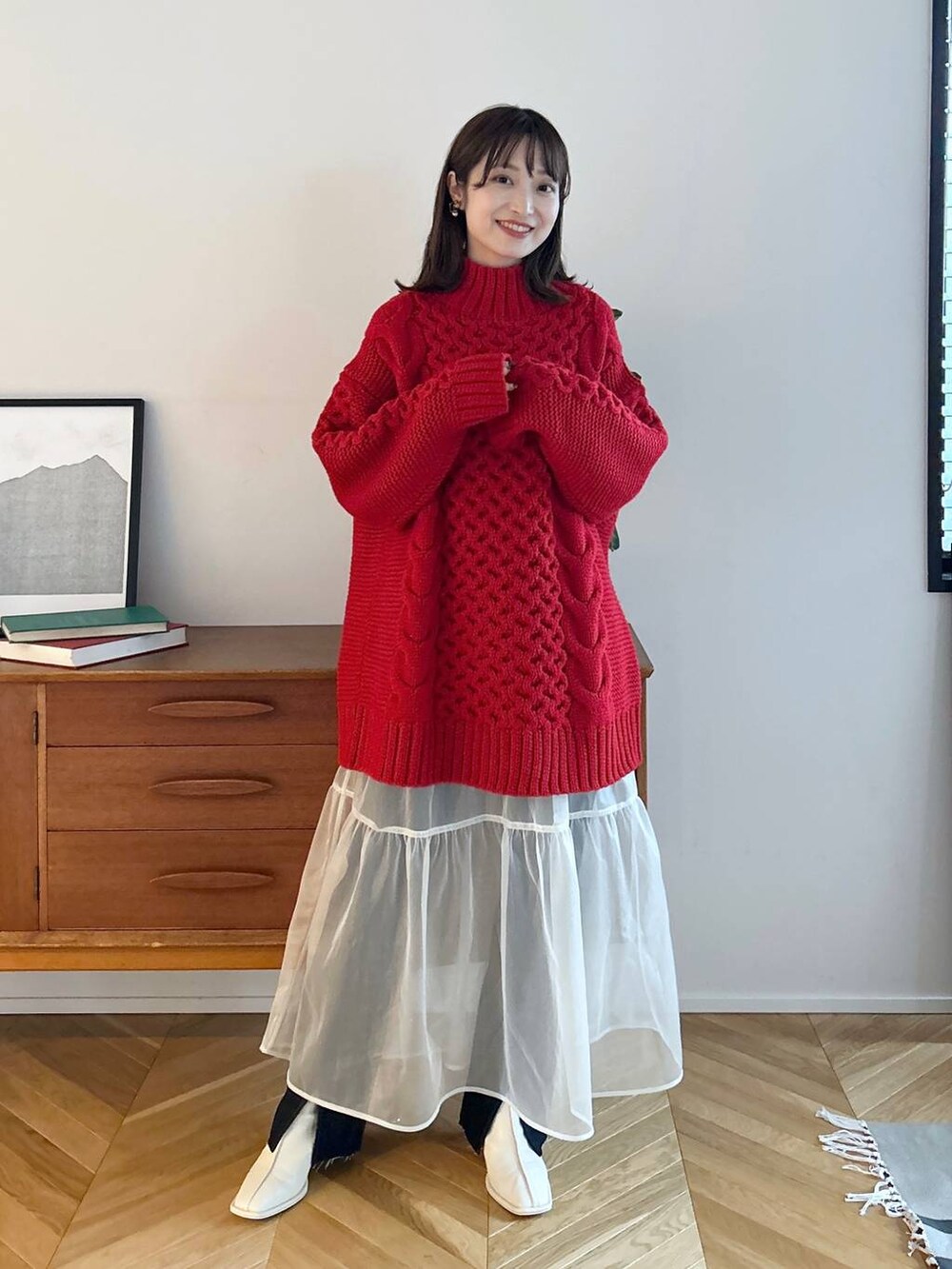 ブルー系のデニムパンツ、ホワイト系のパンプス、ホワイト系のスカートを着用したレディースの秋コーディネートの3枚目の写真