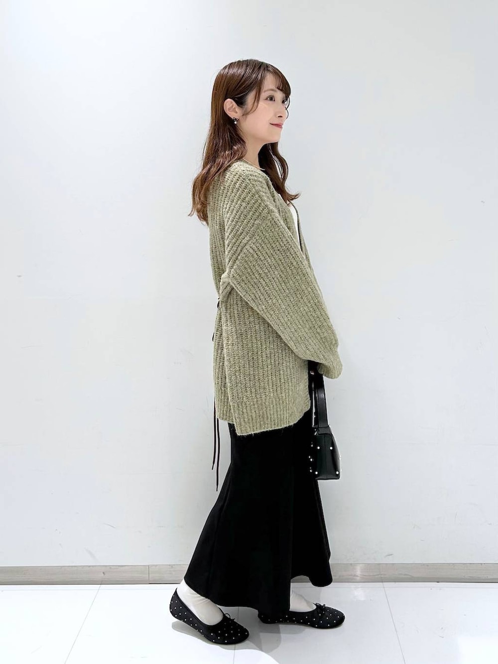 ホワイト系のタンクトップ、ブラック系のバレエシューズ、ブラック系のスカートを着用したレディースの秋コーディネートの4枚目の写真