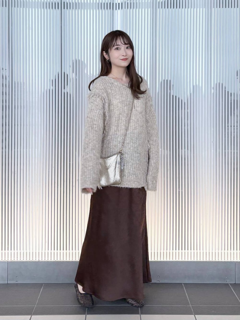 ゴールド系のショルダーバッグ、ホワイト系のニット/セーター、その他のバレエシューズを着用したレディースの夏コーディネートの2枚目の写真