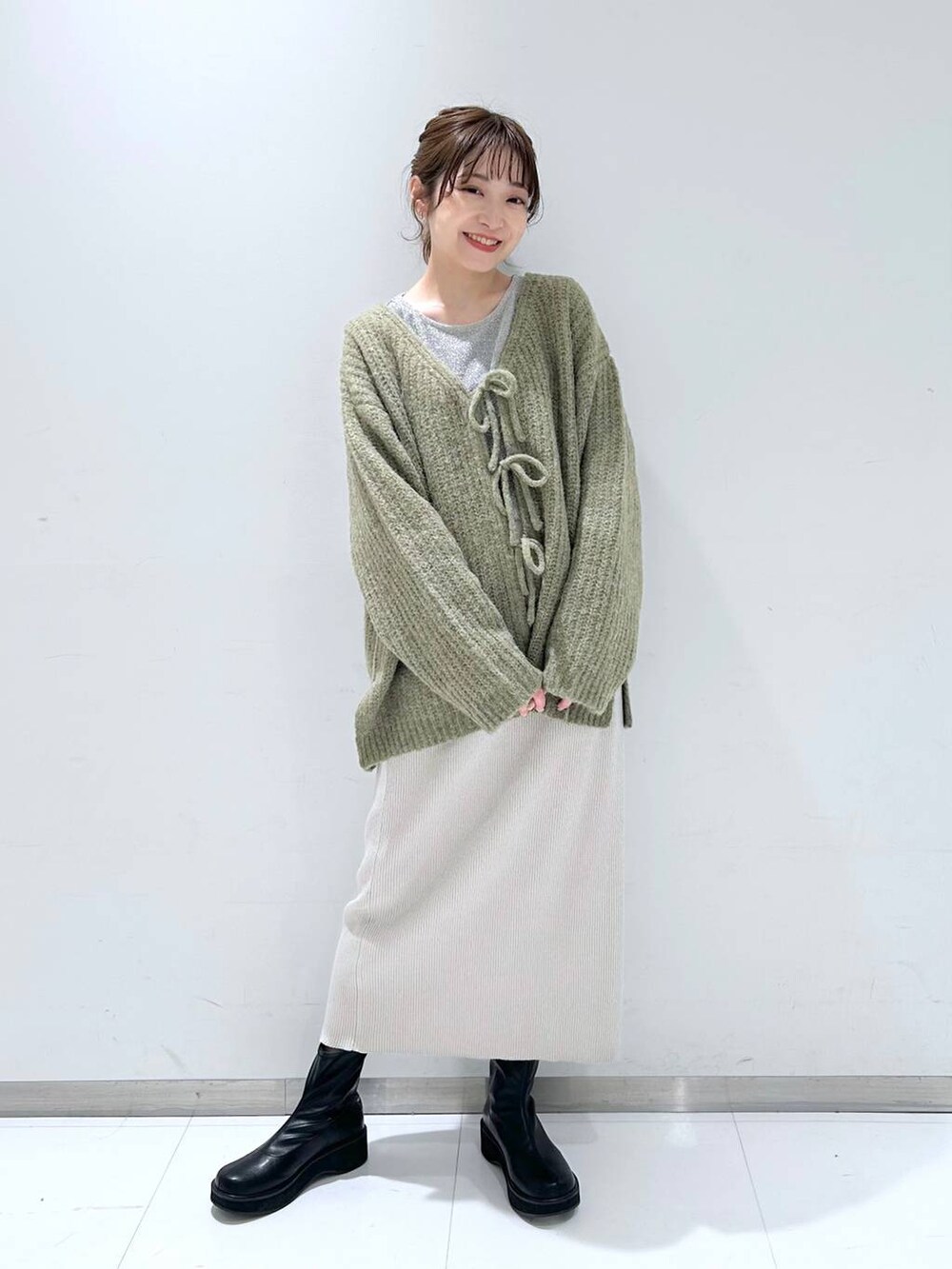 ブラック系のブーツ、ホワイト系のTシャツ/カットソー、グリーン系のTシャツ/カットソーを着用したレディースの冬コーディネートの2枚目の写真
