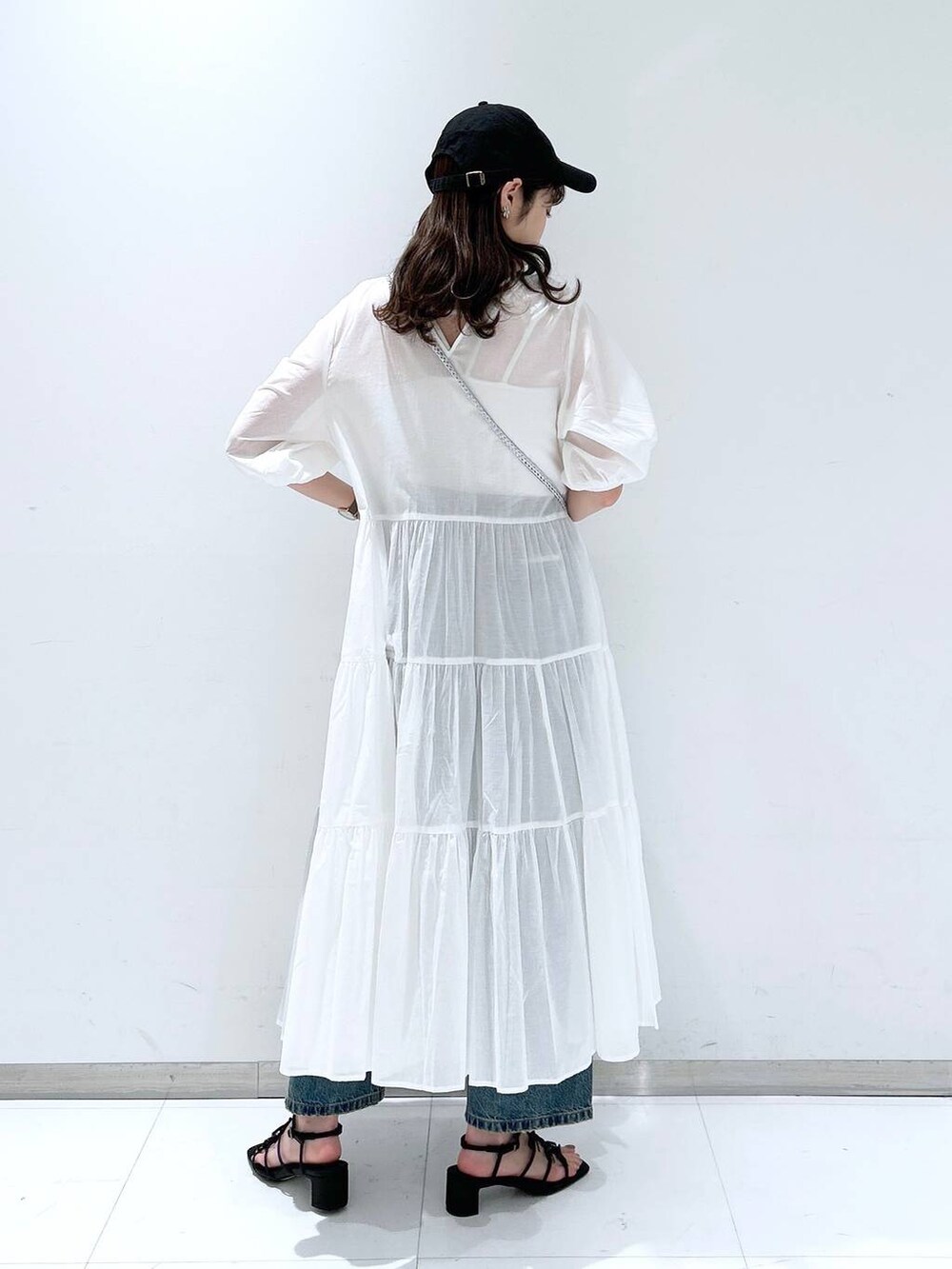 ホワイト系のTシャツ/カットソー、ブラック系のサンダル、ブルー系のデニムパンツを着用したレディースの春コーディネートの5枚目の写真