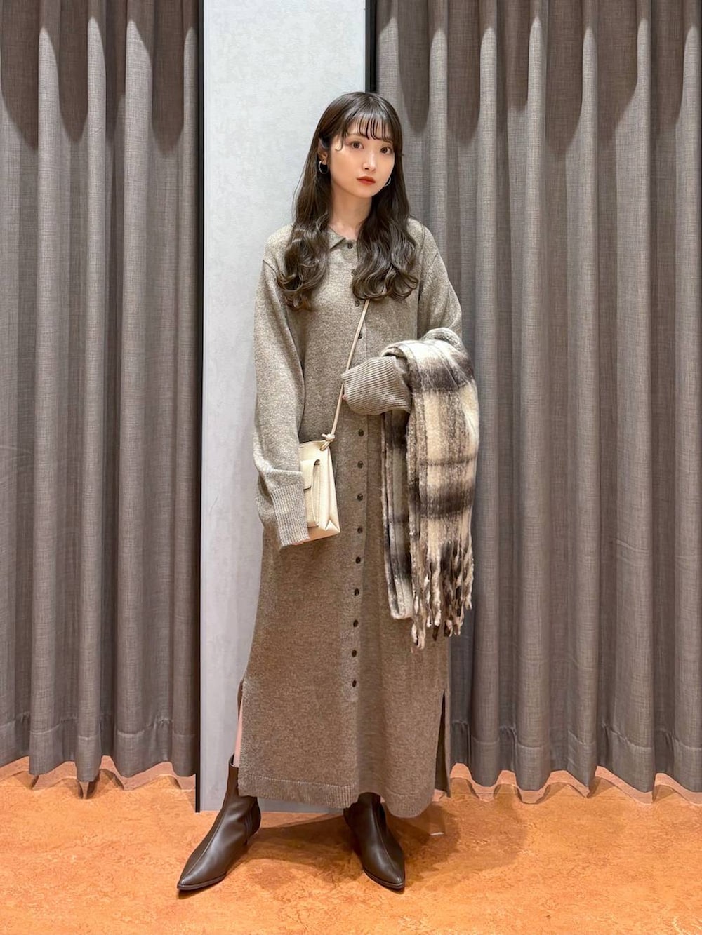 ホワイト系のその他アウター、ブラウン系のブーツ、ブラウン系のワンピースを着用したレディースの秋コーディネートの4枚目の写真