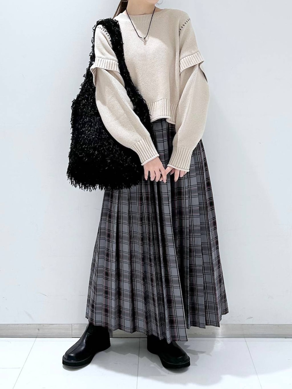 ホワイト系のTシャツ/カットソー、ブラック系のブーツ、ブラック系のトートバッグを着用したレディースの冬コーディネートの2枚目の写真