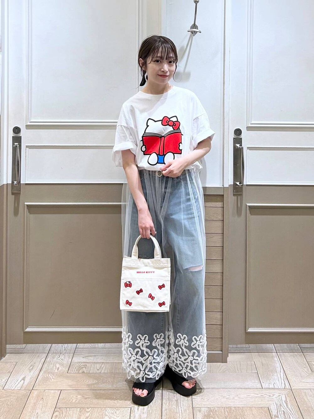 ブラック系のサンダル、ブルー系のデニムパンツ、ホワイト系のその他パンツを着用したレディースの夏コーディネートの2枚目の写真