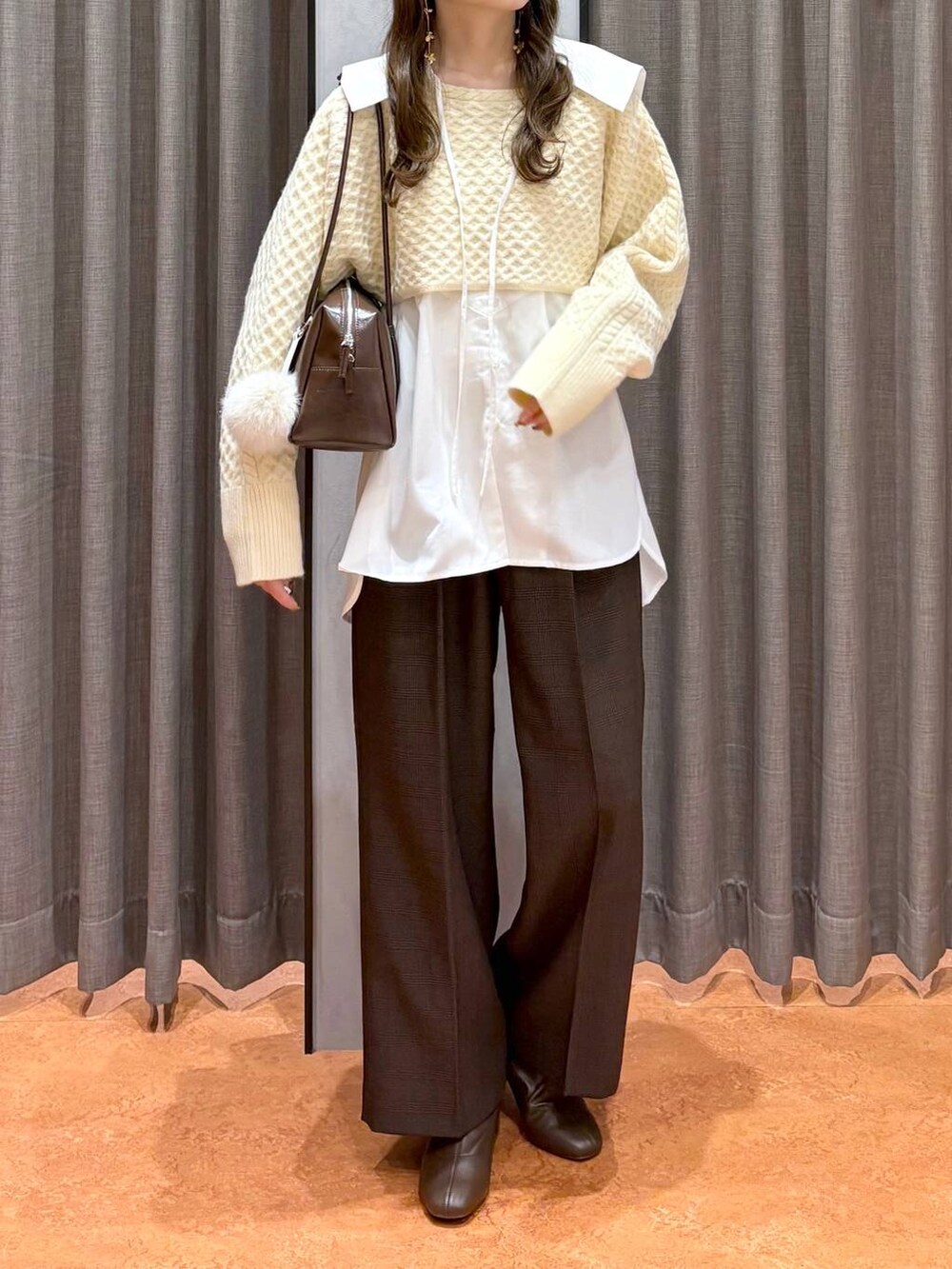 ブラウン系のその他パンツ、ブラウン系のボストンバッグ、ホワイト系のシャツ/ブラウスを着用したレディースの秋コーディネートの2枚目の写真