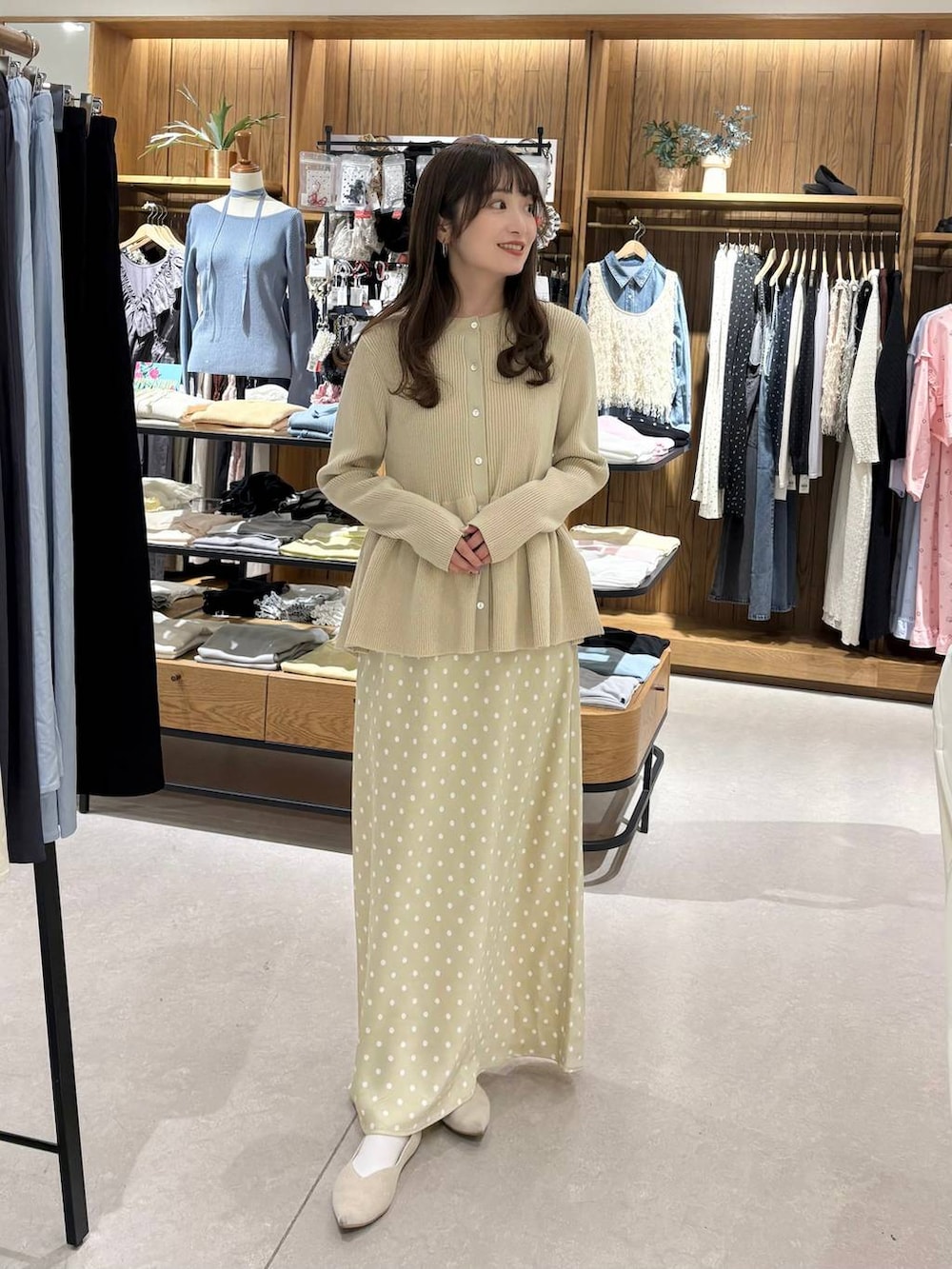 ベージュ系のスカート、ホワイト系のパンプス、ホワイト系のカーディガン/ボレロを着用したレディースの春コーディネートの2枚目の写真