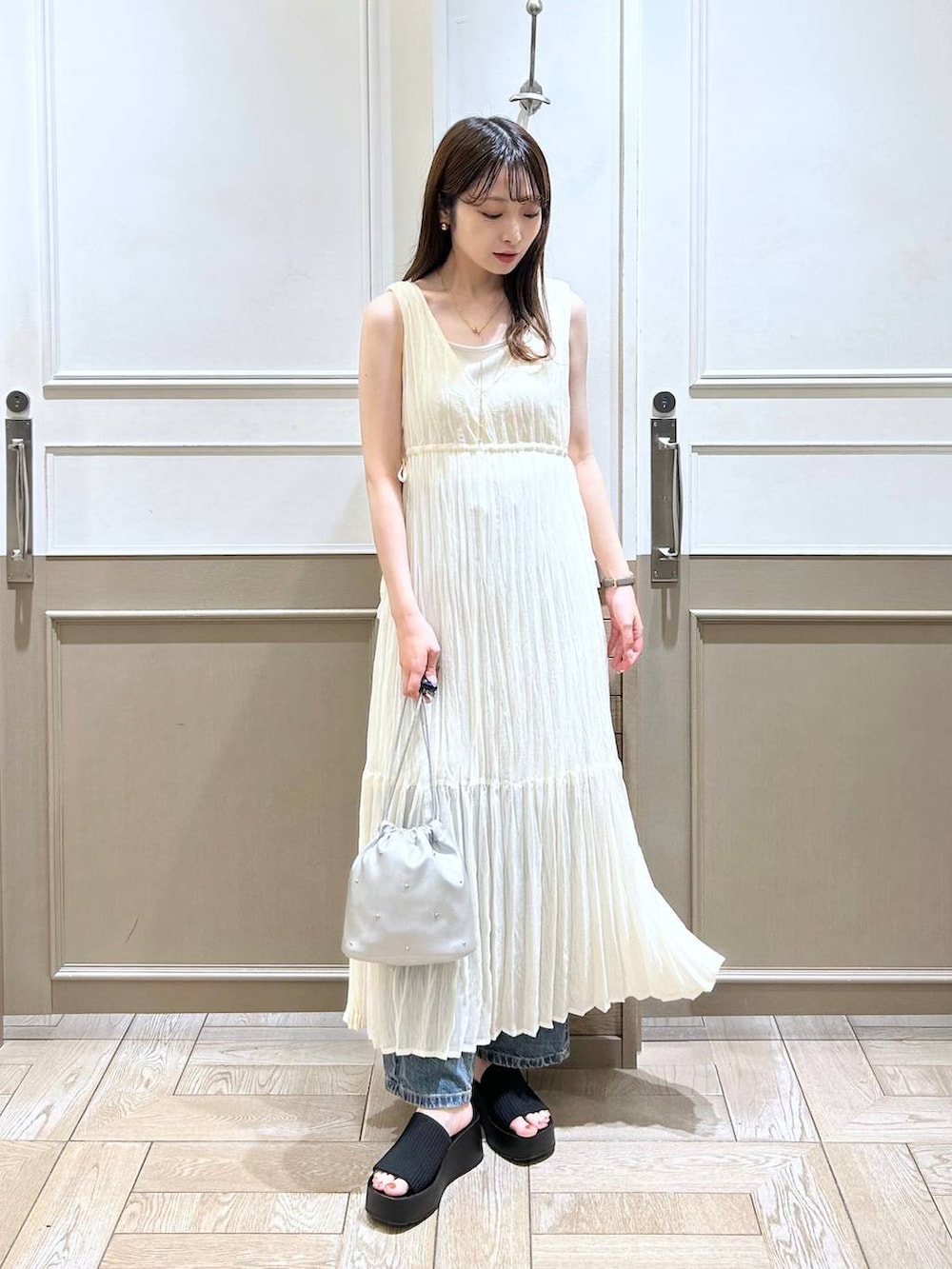 ホワイト系のTシャツ/カットソー、ブラック系のサンダル、ブルー系のデニムパンツを着用したレディースの夏コーディネートの2枚目の写真