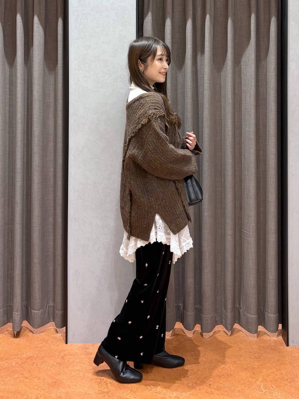 ブラウン系のニット/セーター、ホワイト系のニット/セーター、ブラウン系のムートンコートを着用したレディースの冬コーディネートの7枚目の写真