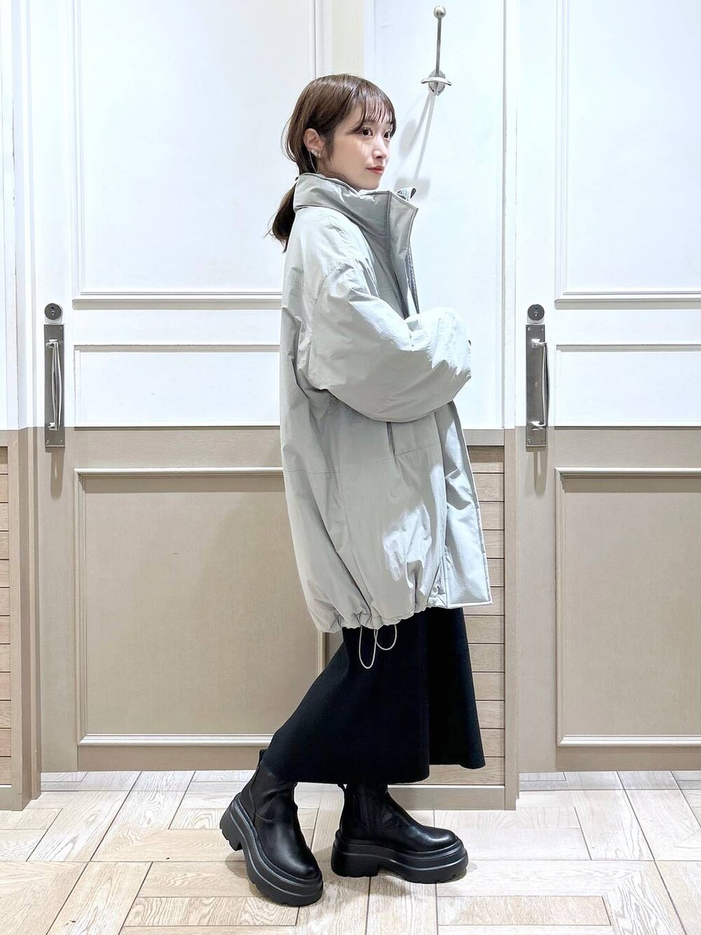 ホワイト系のTシャツ/カットソー、グリーン系のダウンジャケット/コート、ブラック系のブーツを着用したレディースの冬コーディネートの3枚目の写真